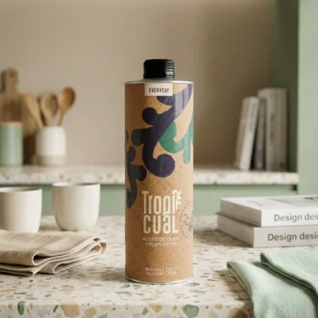 Die Tropicual Everyday Olivenöl-Dose steht auf einer hellen Terrazzo-Küchenarbeitsplatte. Im unscharfen Hintergrund sind pastellgrüne Küchenelemente, Kaffeetassen, Bücher und Holzschneidebretter zu sehen.